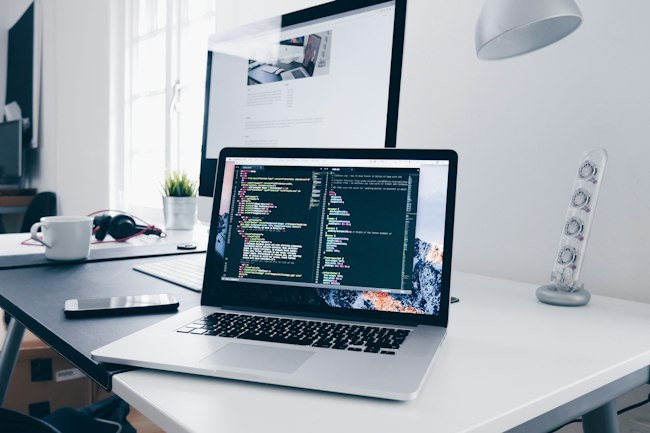 Laptop with code on a creative workspace